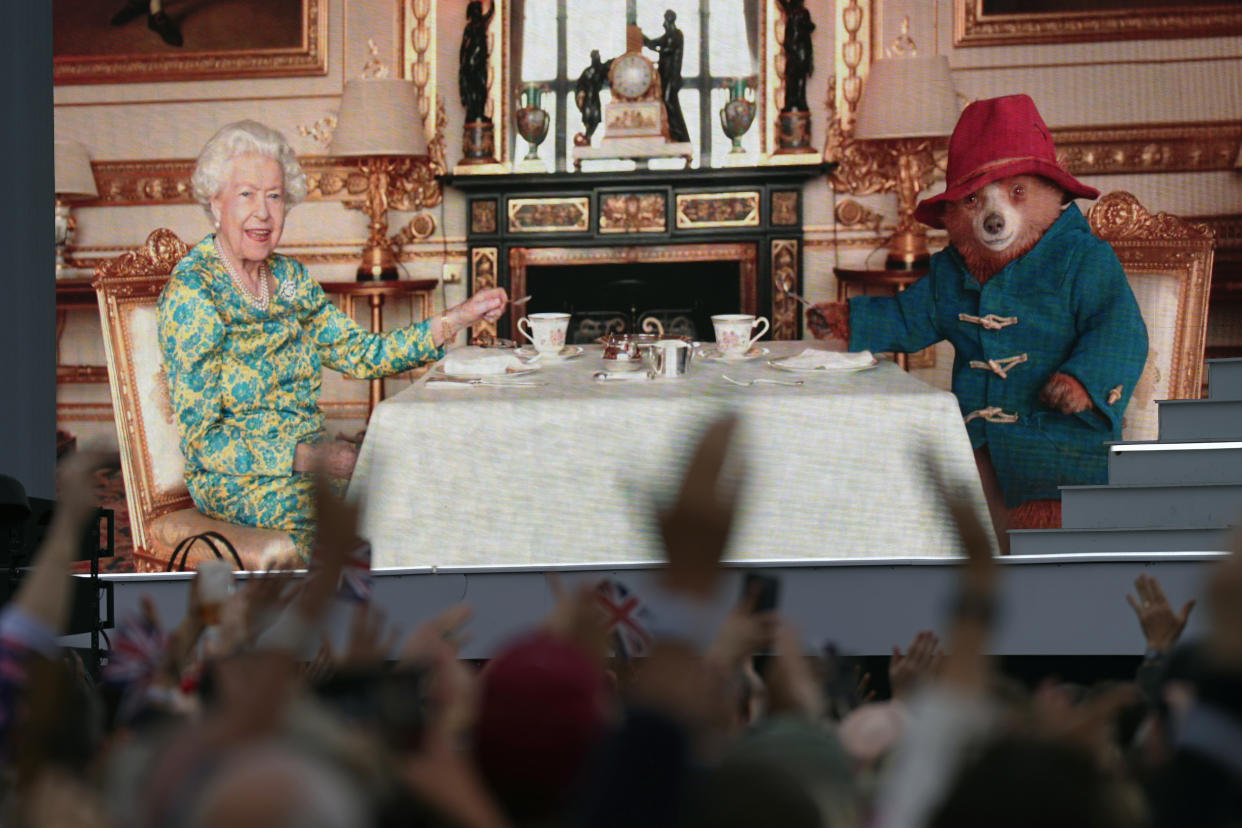 The crowd watching a film of Queen Elizabeth II having tea with Paddington Bear on a big screen during the Platinum Party at the Palace staged in front of Buckingham Palace, London on day three of the Platinum Jubilee celebrations for Queen Elizabeth II. Picture date: Saturday June 4, 2022. (Photo by Victoria Jones/PA Images via Getty Images)