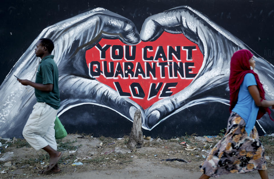 Pedestrians walk past a coronavirus information mural on a street in Mombasa, Kenya Monday, Sept. 27, 2021. (AP Photo/Brian Inganga)