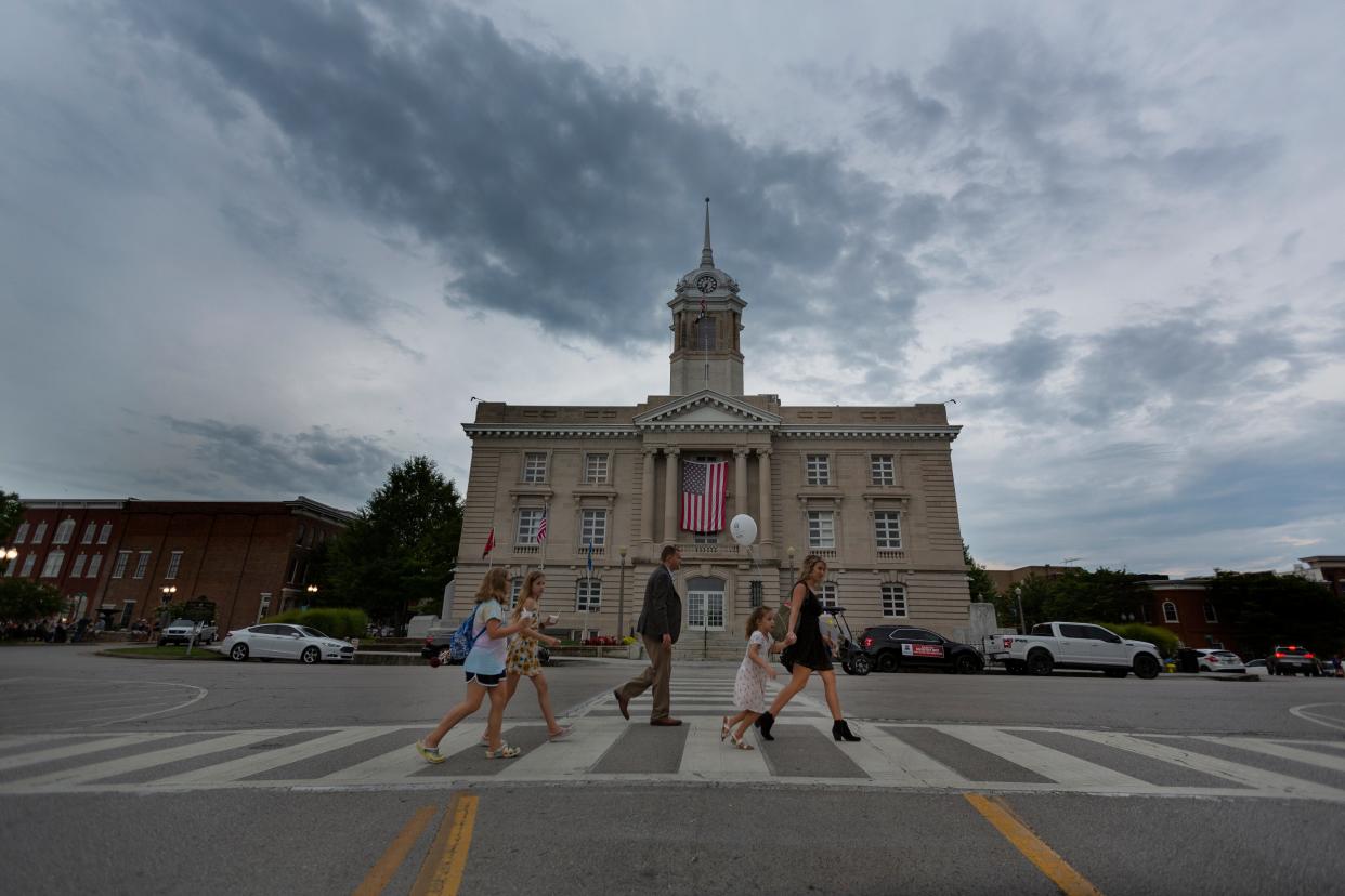 Pedestrians walk in front of the Maury County Courthouse during a First Fridays event in downtown Columbia, Tenn., on Friday, Aug., 8, 2021. 