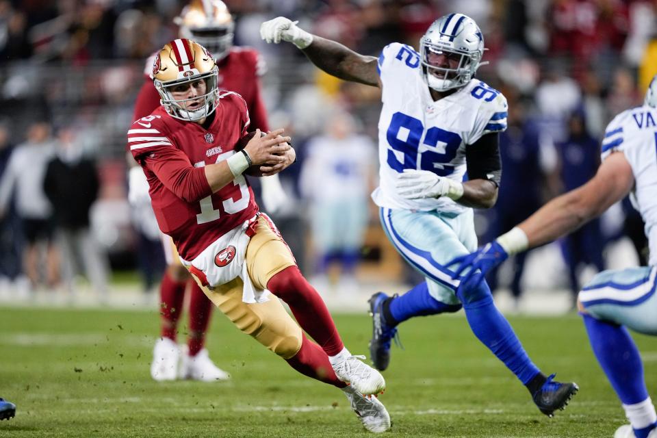 San Francisco 49ers quarterback Brock Purdy (13) runs against Dallas Cowboys defensive end Dorance Armstrong (92) during the second half of an NFL divisional round playoff football game in Santa Clara, Calif., Sunday, Jan. 22, 2023.