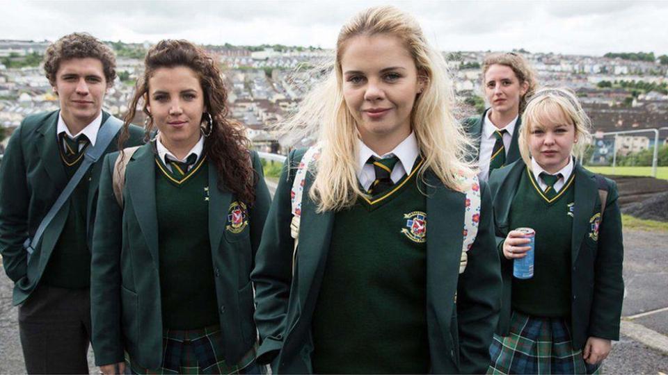 Promotional shot of the cast of Derry Girls, featuring the five main characters all wearing a green school uniform