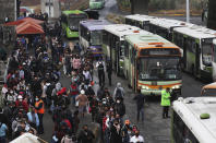 Commuters, most who use the Line 12 subway daily to get across the city, line up to board buses on the south side of Mexico City, Thursday, May 6, 2021, after a Monday collapse on Line 12 left it out of service. At its farthest point, Line 12 carries commuters from the capital’s still semi-rural south side to jobs across the city. Some 220,000 riders use Line 12 every day. (AP Photo/Marco Ugarte)