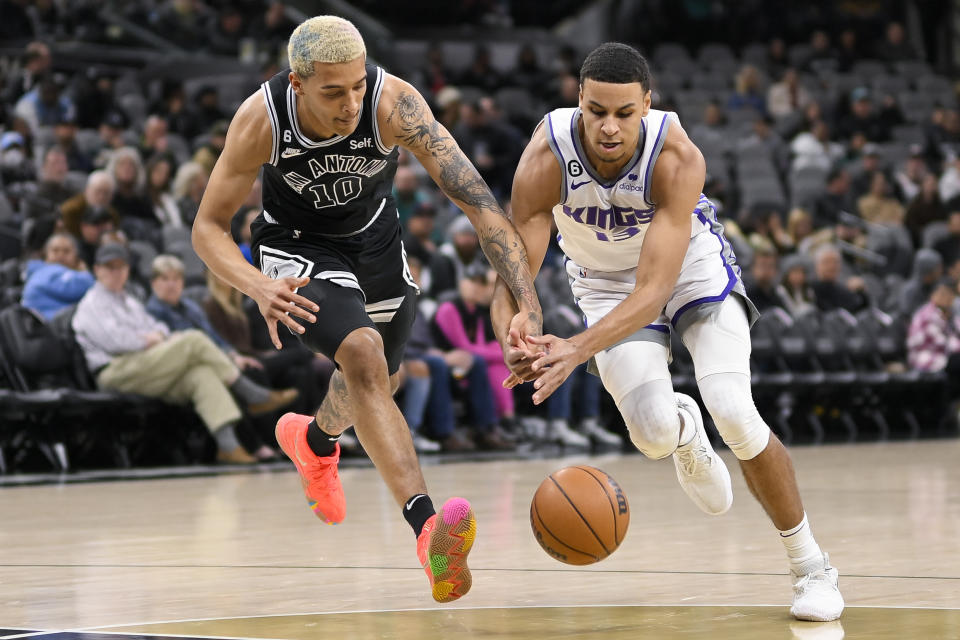 Sacramento Kings' Keegan Murray, right, and San Antonio Spurs' Jeremy Sochan fight for possession during the first half of an NBA basketball game, Wednesday, Feb. 1, 2023, in San Antonio. (AP Photo/Darren Abate)