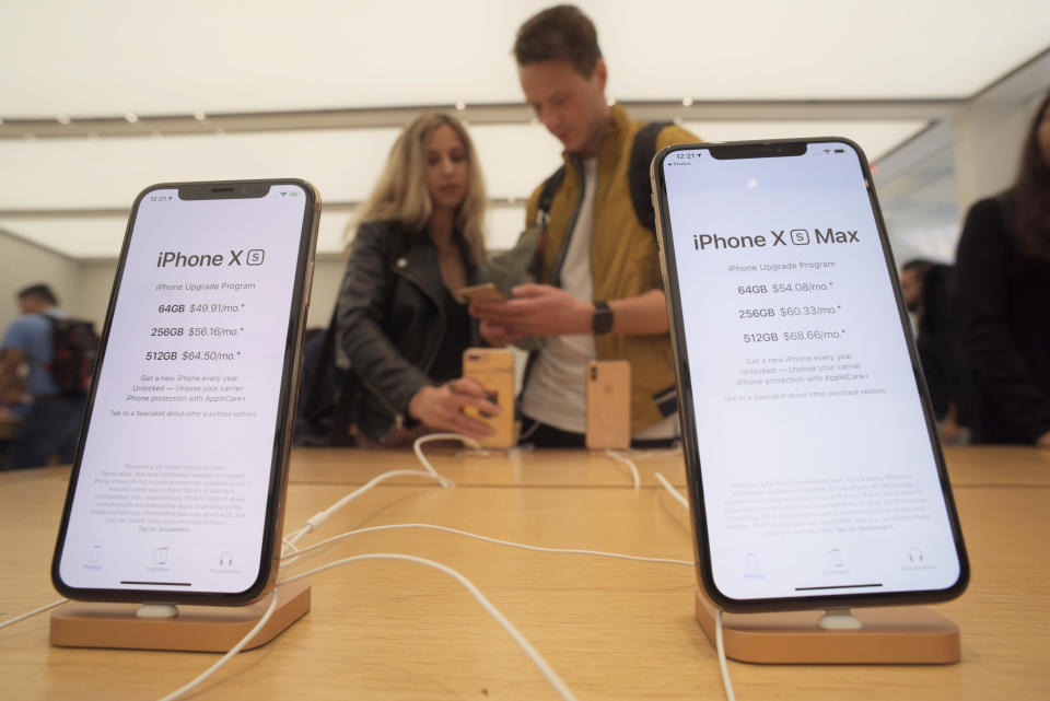 Customers look at new Apple iPhones including the iPhone XS, left, iPhone XS Max on display at an Apple store in New York on Friday, Sept. 21, 2018. (AP Photo/Patrick Sison)