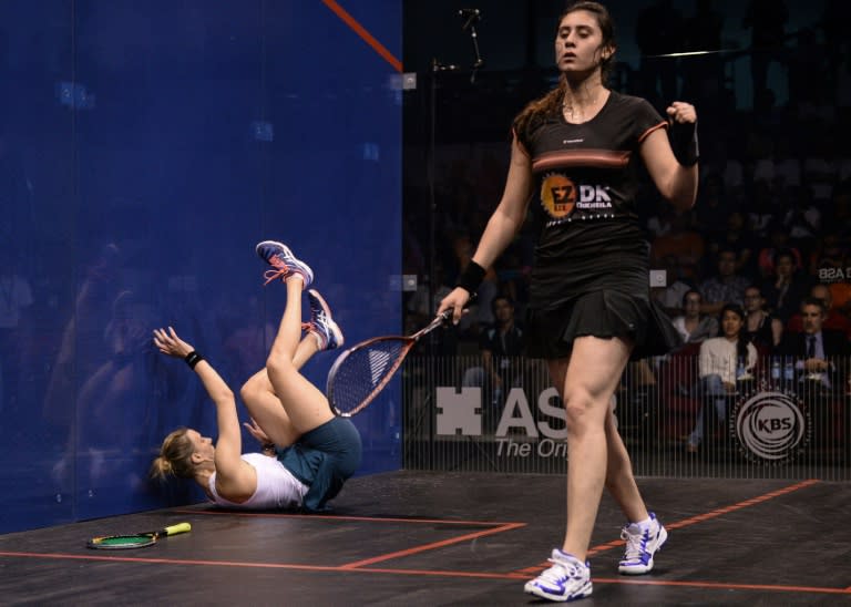 Nour El Sherbini of Egypt (R) celebrates a point as Laura Massaro of England (L) falls down during their final match of the PSA Women's World Championships squash tournament in Bukit Jalil, oustide Kuala Lumpur on April 30, 2016