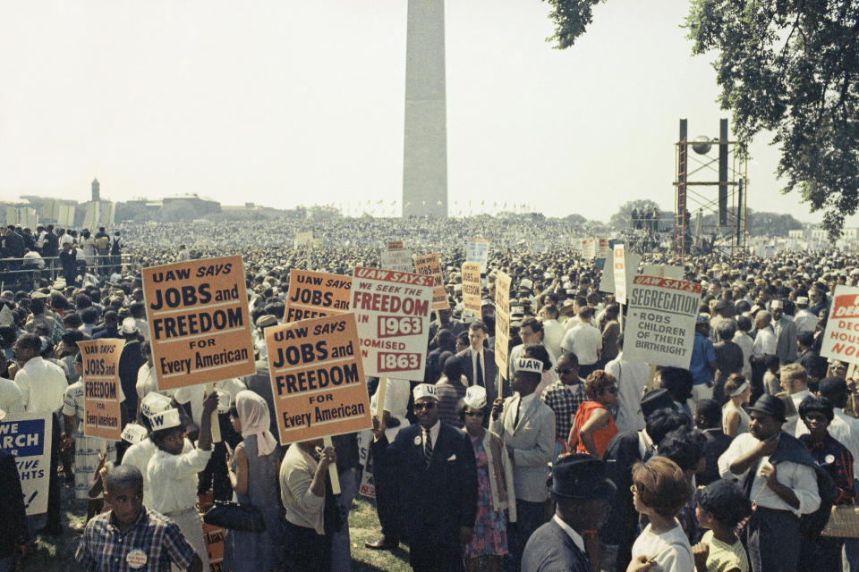 Attendees of the March on Washington hold signs saying "Jobs and Freedom for Every American."