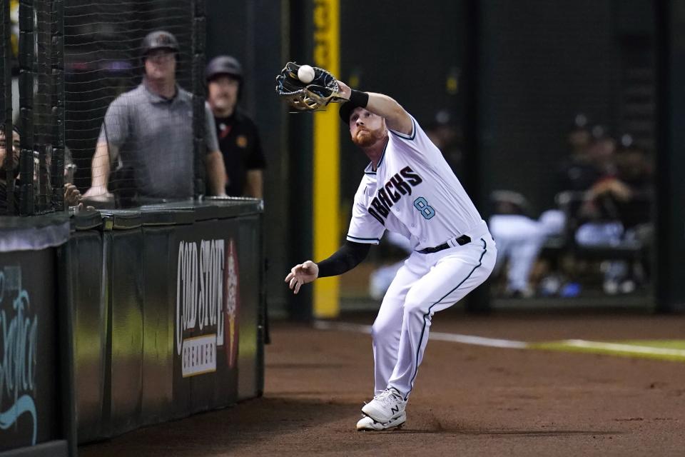 Arizona Diamondbacks left fielder Jordan Luplow makes a catch on a foul ball hit by San Diego Padres' Jurickson Profar during the fourth inning of a baseball game Tuesday, June 28, 2022, in Phoenix. (AP Photo/Ross D. Franklin)