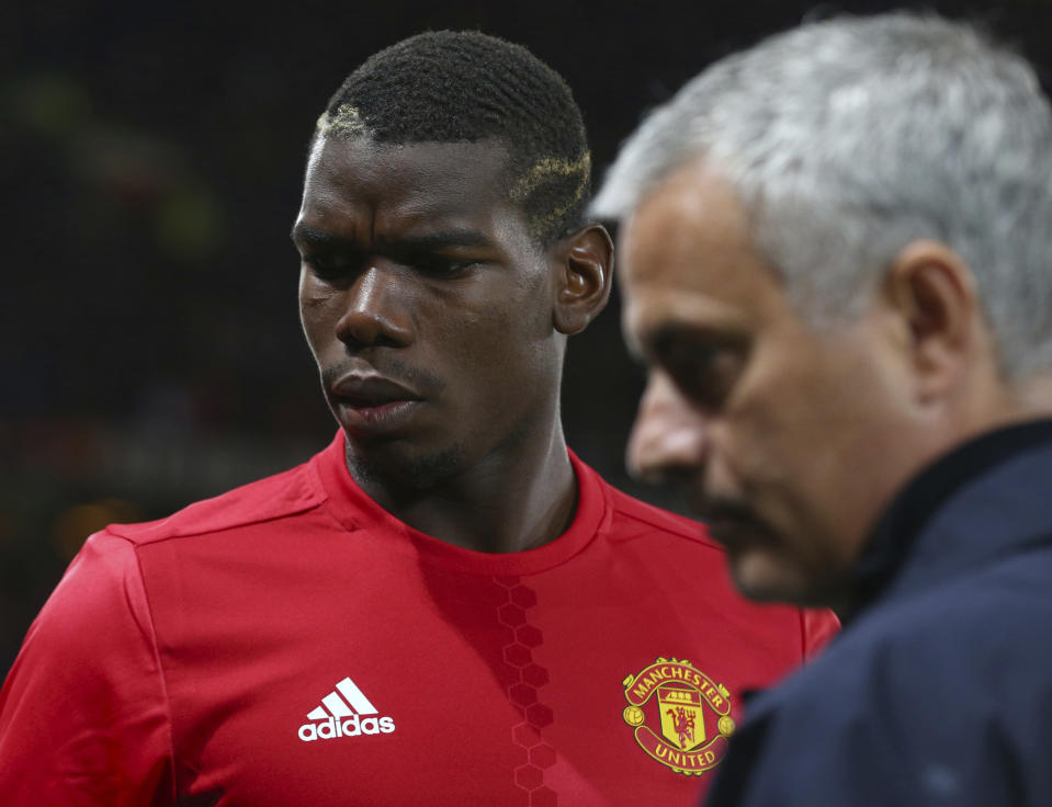 FILE - In this Thursday, Sept. 29, 2016 file photo Manchester United's manager Jose Mourinho, right, with Manchester United's Paul Pogba just prior to the start of Europa League group A soccer match between Manchester United and Zorya Luhansk at Old Trafford, Manchester, England. Manchester United says Jose Mourinho has left the Premier League club with immediate effect. The decision was announced Tuesday Dec.18, 2018, two days after a 3-1 loss to Liverpool left United 19 points off the top of the Premier League after 17 games. (AP Photo/Dave Thompson, File)