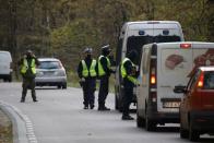 Polish police officers examine vehicles at a checkpoint on entry to the prohibited state of emergency zone, created to better manage an ongoing migrant crisis on the Belarusian-Polish border near Bialowieza