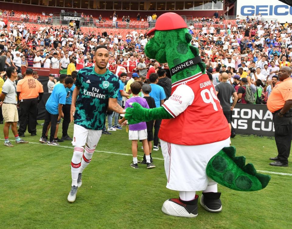 Arsenal striker Pierre-Emerick Aubameyang with mascot Gunnersaurus in 2019Arsenal FC via Getty Images