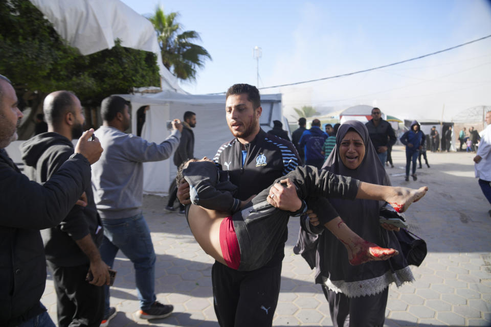 Wounded Palestinians run into Al-Aqsa Hospital In Deir al Balah, Gaza Strip, moments after an Israeli strike hit a building next to it on Wednesday, Jan. 10, 2024. (AP Photo/Hatem Moussa)