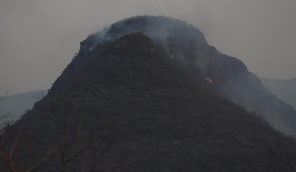 Smoke causes by wildfires rises from the Ipias mountains near Robore, Bolivia, Friday, Aug. 23, 2019. Bolivia, along with Brazil, is struggling to contain wildfires, many believed to have been set by farmers clearing land for cultivation. (AP Photo/Juan Karita)