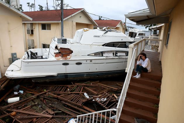 Brenda Brennan sits next to a boat Thursday that pushed against her apartment when Hurricane Ian passed through the Fort Myers area. (Photo: Joe Raedle via Getty Images)