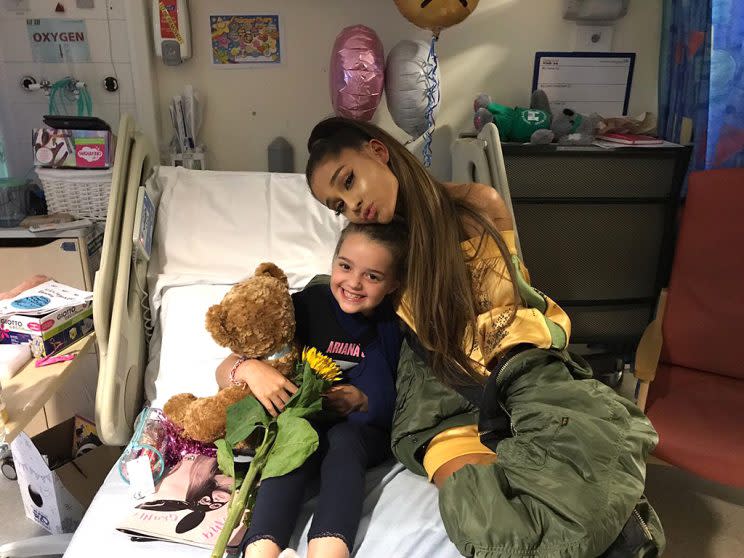 Ariana Grande cuddled with 8-year-old Lily Harrison. (Photo: Adam Harrison via Twitter)