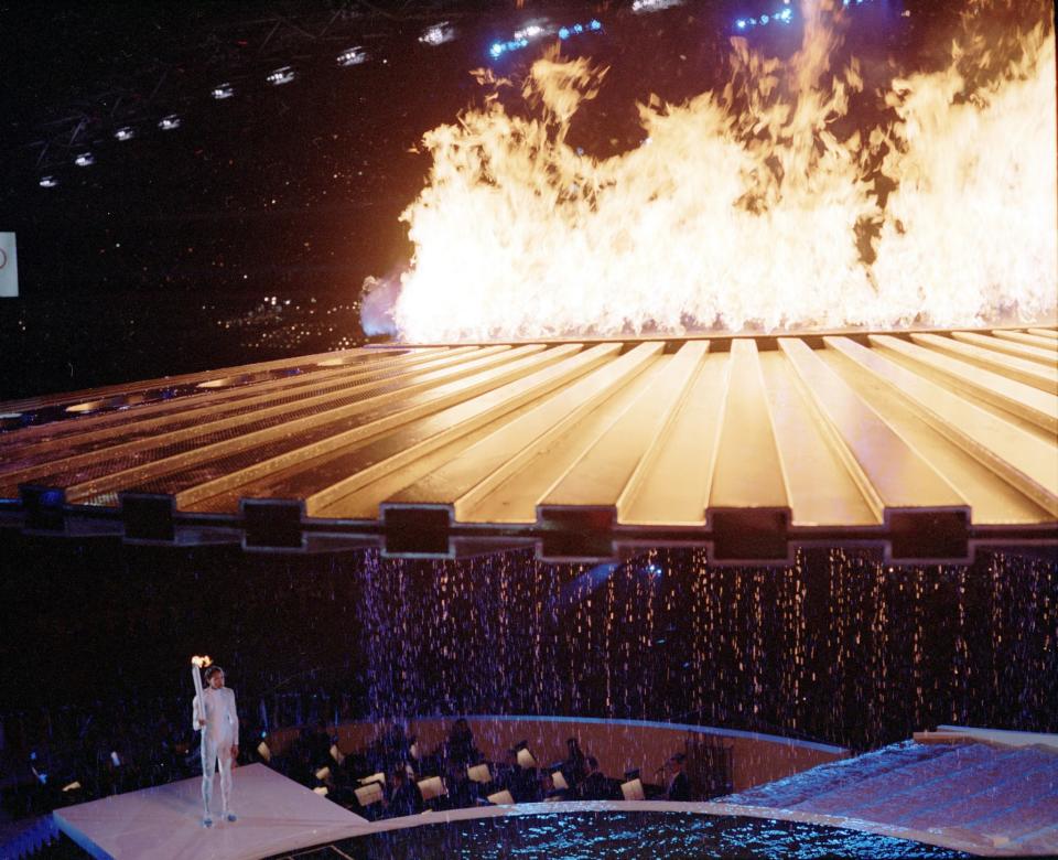 <p>Torch Bearer Cathy Freeman made a dramatic entrance for the Sydney 2000 Olympic Games Opening Ceremony. The sprinter lit a ring of fire in a pool and waited for a saucer-like contraption to rise above her. But it didn’t. For four agonizing minutes, she smiled and waited. A computer glitch was finally fixed and the flame flew up to meet the cauldron. (Ben EltersGetty Images) </p>