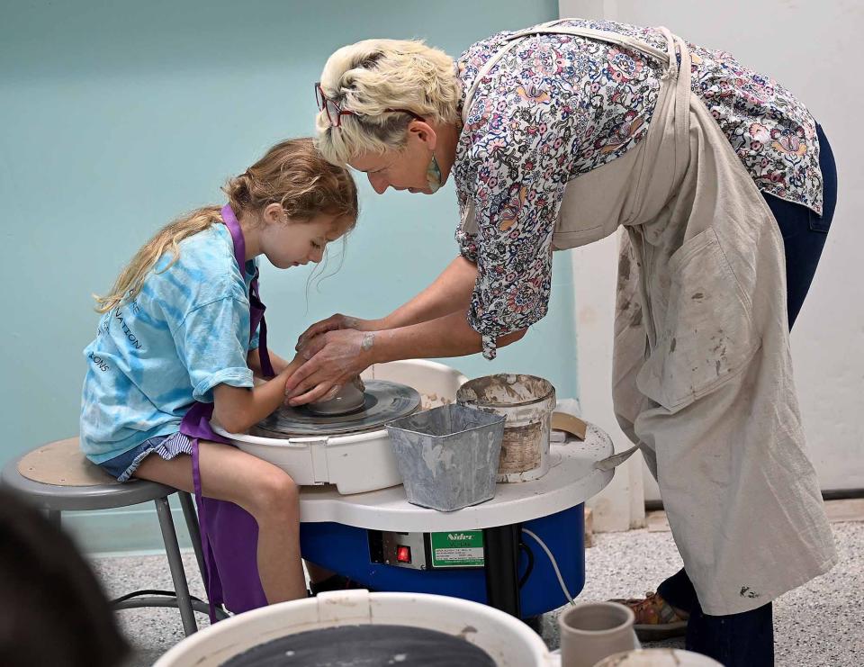 Instructor Kathy Wotton helps Mya Morris, 9, of Bellingham, create a cylinder made of white clay during a beginner pottery class at ConnectEd & Inspired in Bellingham, Sept. 22, 2022.
