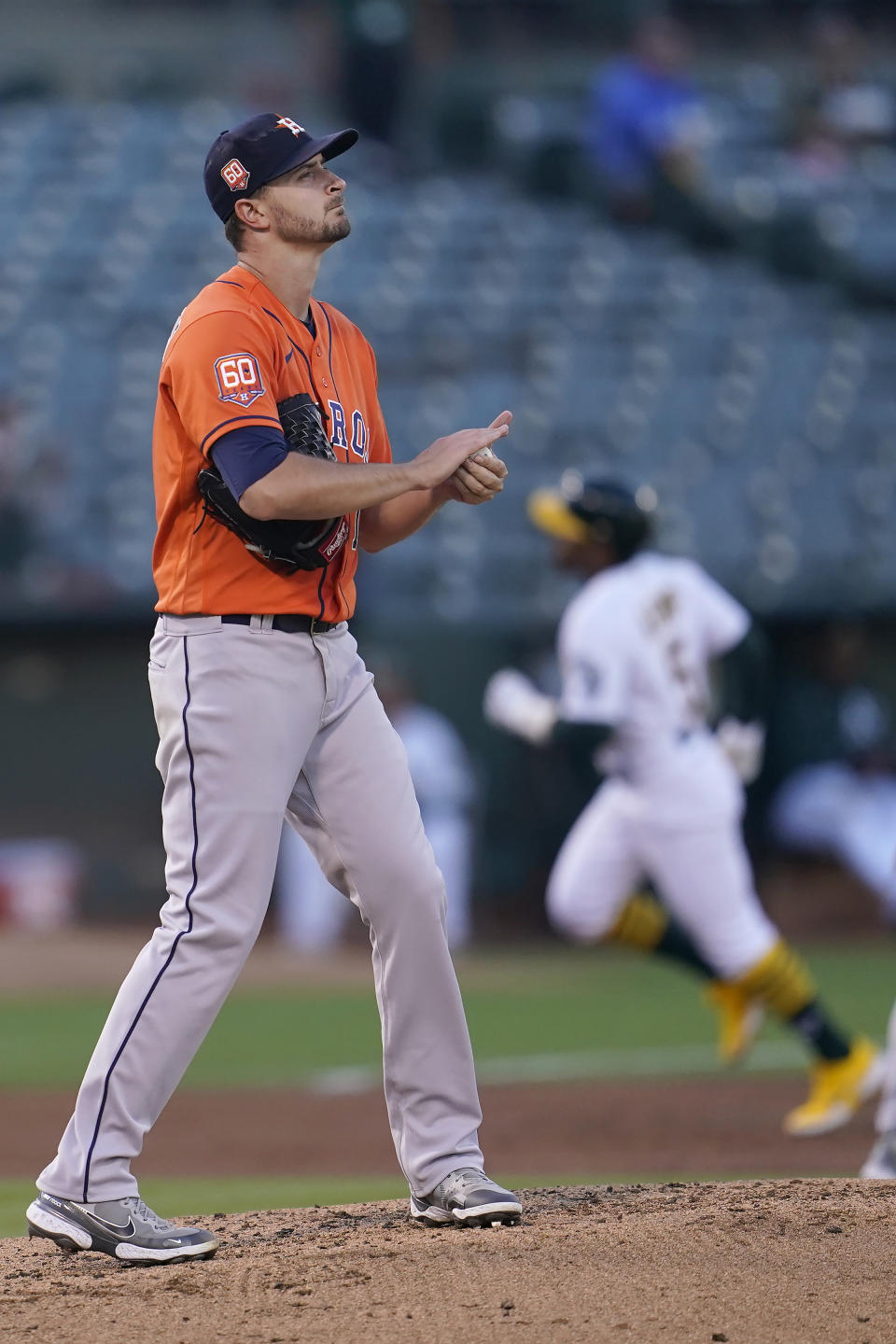 Houston Astros pitcher Jake Odorizzi, foreground, reacts after Oakland Athletics' Tony Kemp, rear, hit a home run during the third inning of a baseball game in Oakland, Calif., Monday, July 25, 2022. (AP Photo/Jeff Chiu)