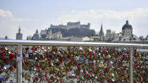 Looks hang on the fence of the Makartsteg in Salzburg, Austria, Friday, April 3, 2020. The Austrian government has moved to restrict freedom of movement for people, in an effort to slow the onset of the COVID-19 coronavirus. (AP Photo/Kerstin Joensson)