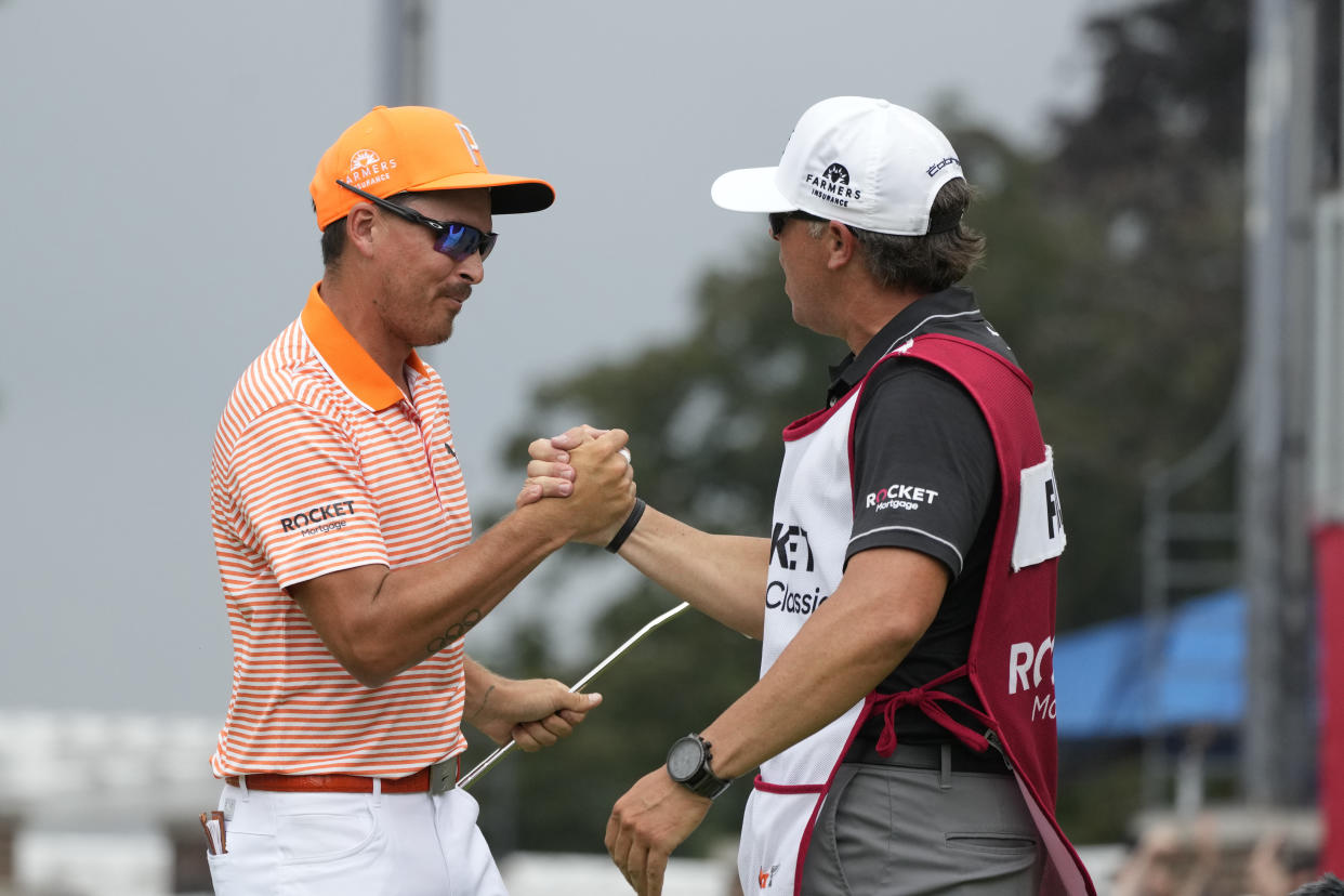 Rickie Fowler (left) celebrates with caddie Ricky Romano after winning the Rocket Mortgage Classic at Detroit Country Club, Sunday, July 2, 2023, in Detroit. (AP Photo/Carlos Osorio)