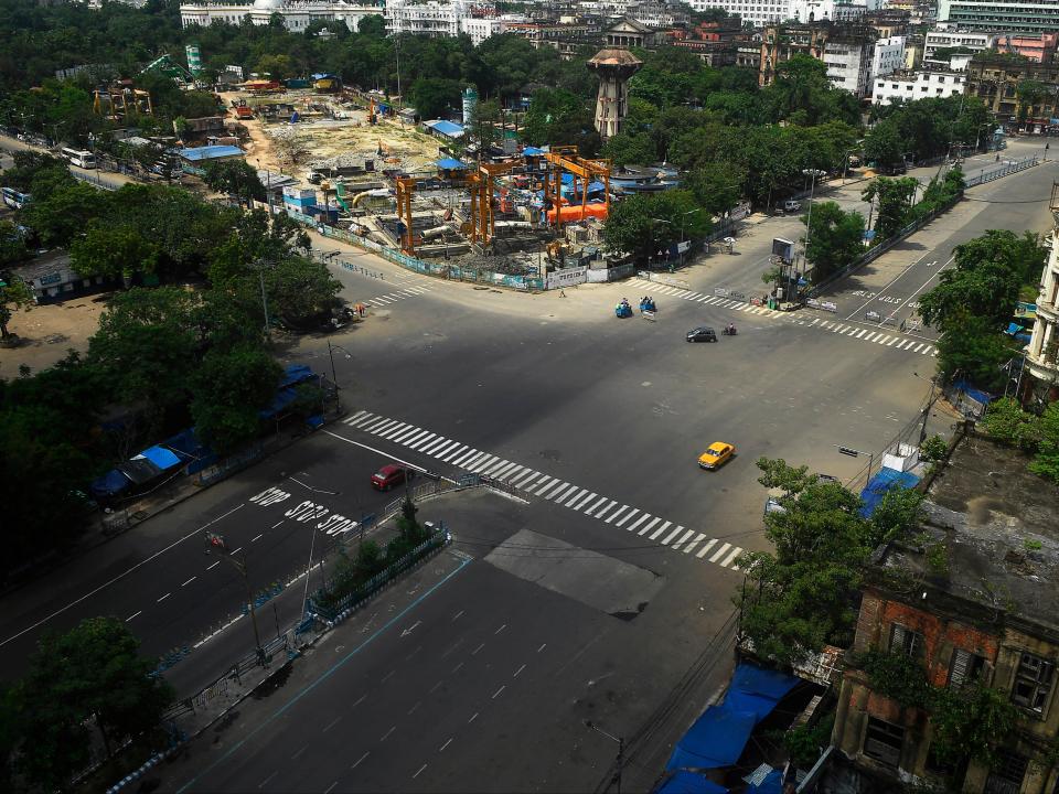 Commuters cross a deserted road during a day-long state-imposed lockdown as a preventive measure against the Covid-19 in KolkataAFP via Getty Images