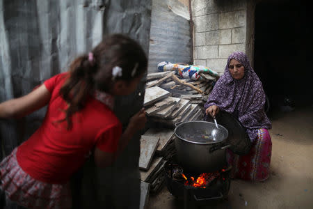 A Palestinian woman cooks on a wood fire at her house during power cut in Beit Lahiya town in the northern Gaza Strip July 6, 2017. REUTERS/Mohammed Salem