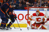 Calgary Flames goalie Jacob Markstrom, right, blocks the net on Edmonton Oilers winger Zach Hyman, center, during the first period of Game 4 of an NHL hockey Stanley Cup playoffs second-round series Tuesday, May 24, 2022, in Edmonton, Alberta. (Jeff McIntosh/The Canadian Press via AP)