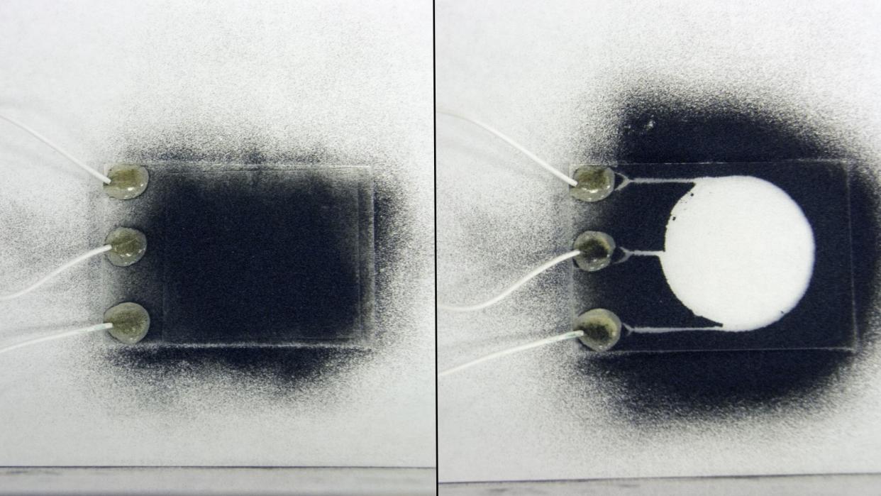  Two images; the one on the left shows a small rectangle of glass covered in black dust; the one on the right shows a clear circle with no dust on the same glass rectangle. 