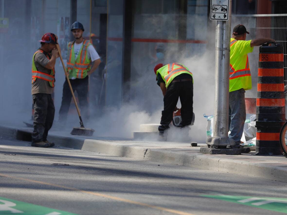 A construction crew works on a small section of Ottawa's 2,135 kilometres of sidewalk in July 2020. (Andrew Lee/CBC - image credit)