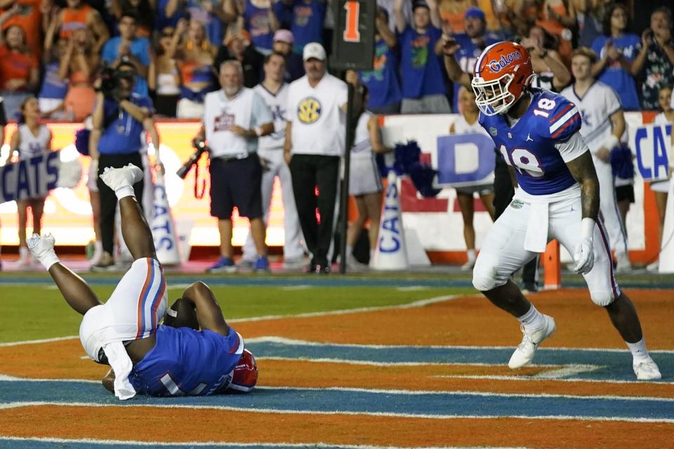 Florida running back Trevor Etienne, left, falls backward after catching a pass for a 2-point conversion against Kentucky as tight end Dante Zanders (18) watches during the first half of an NCAA college football game, Saturday, Sept. 10, 2022, in Gainesville, Fla. (AP Photo/John Raoux)