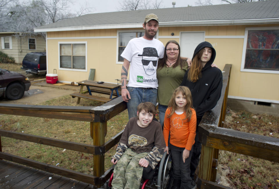 Lori Latch, back row center, with her husband Chad, left rear, son Marcus, right rear, son Eric, front left, and daughter Ruby, front right, at their home in North Little Rock, Ark., Tuesday, Feb. 4, 2014. Lori Latch, 35, said she was looking forward to having health insurance for the first time since she was a teenager. She and her husband, who is self-employed, have racked up more than $5,000 in bills for emergency room visits. Arkansas’ plan for expanding Medicaid by buying private insurance policies for the poor instead of adding them to the rolls was heralded as a model for convincing more Republican-leaning states to adopt a key part of President Barack Obama’s health care overhaul. But less than a year after its approval, the program that has extended health insurance to 83,000 people is on the brink of being abandoned. (AP Photo/Brian Chilson) (AP Photo/Brian Chilson)