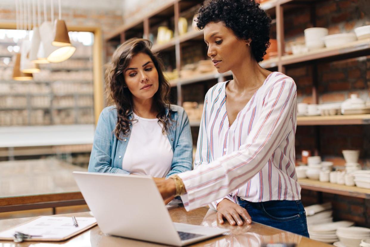 Two young businesswomen using a laptop