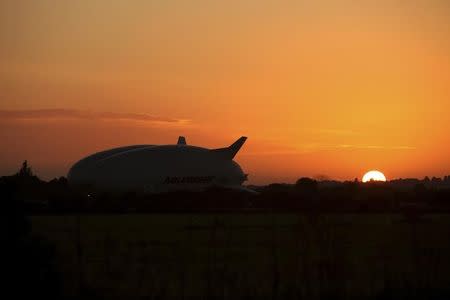 The Airlander 10 hybrid airship is seen at sunrise after it recently left the hangar for the first time to commence ground systems tests before its maiden flight, at Cardington Airfield in Britain August 9, 2016. REUTERS/Gareth Bumstead