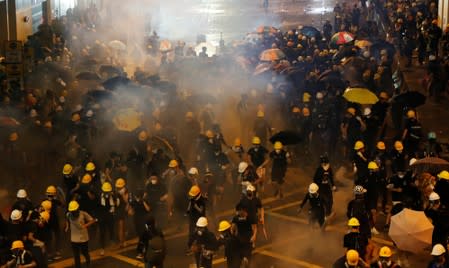 Anti-extradition demonstrators run from tear gas after a march of to call for democratic reforms, in Hong Kong