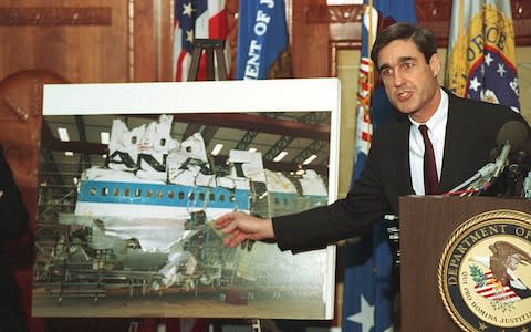 Robert Mueller points to a photo of the reconstructed wreckage of Pan Am Flight 103, which exploded over Lockerbie Scotland in 1988 - Credit: AP