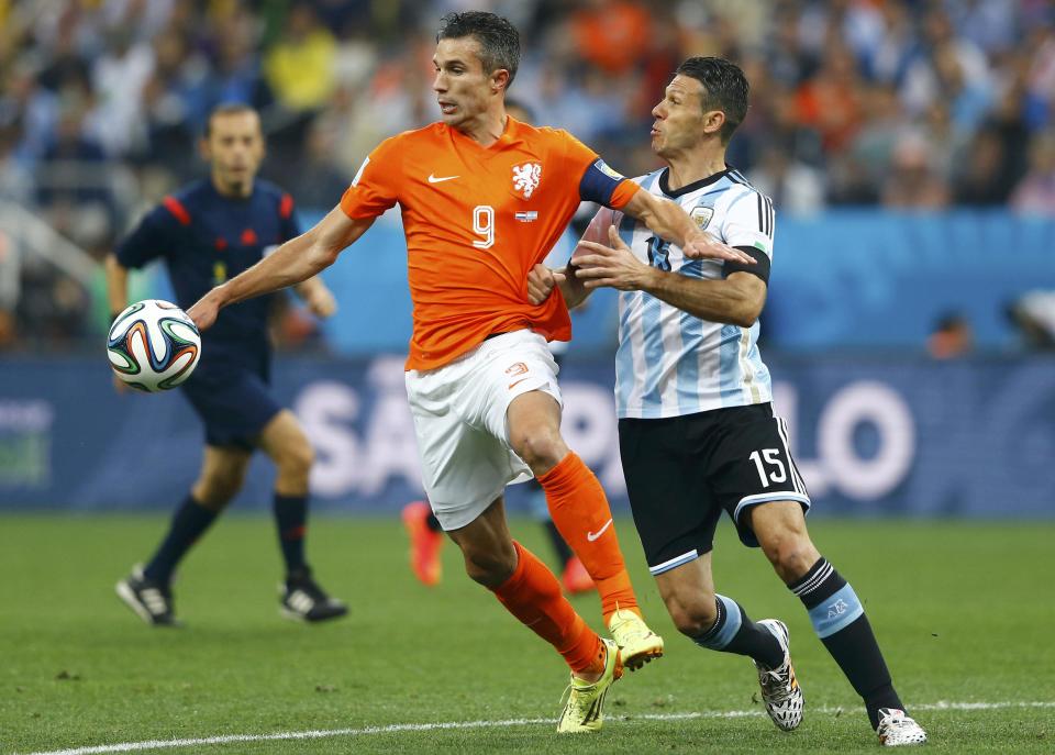 Argentina's Martin Demichelis (R) challenges Robin van Persie of the Netherlands as they fight for the ball during their 2014 World Cup semi-finals at the Corinthians arena in Sao Paulo July 9, 2014. REUTERS/Dominic Ebenbichler