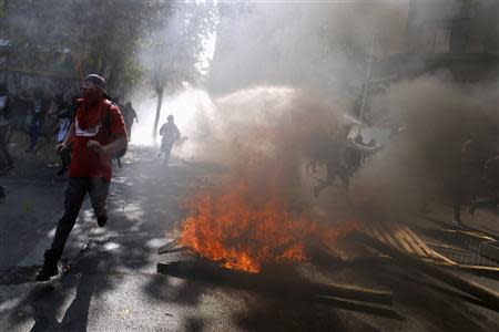 Student protesters run away during a demonstration to demand changes in the Chilean education system, in Santiago May 8, 2014. REUTERS/Ivan Alvarado