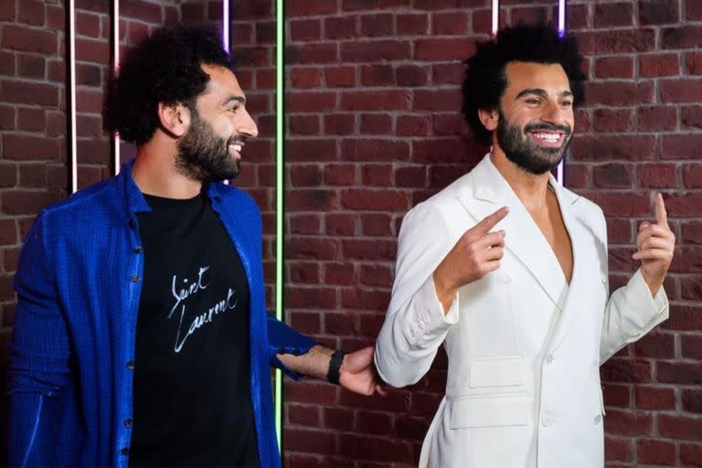 Salah, divertido, junto a su nueva estatua de cera; en Inglaterra lo adoran