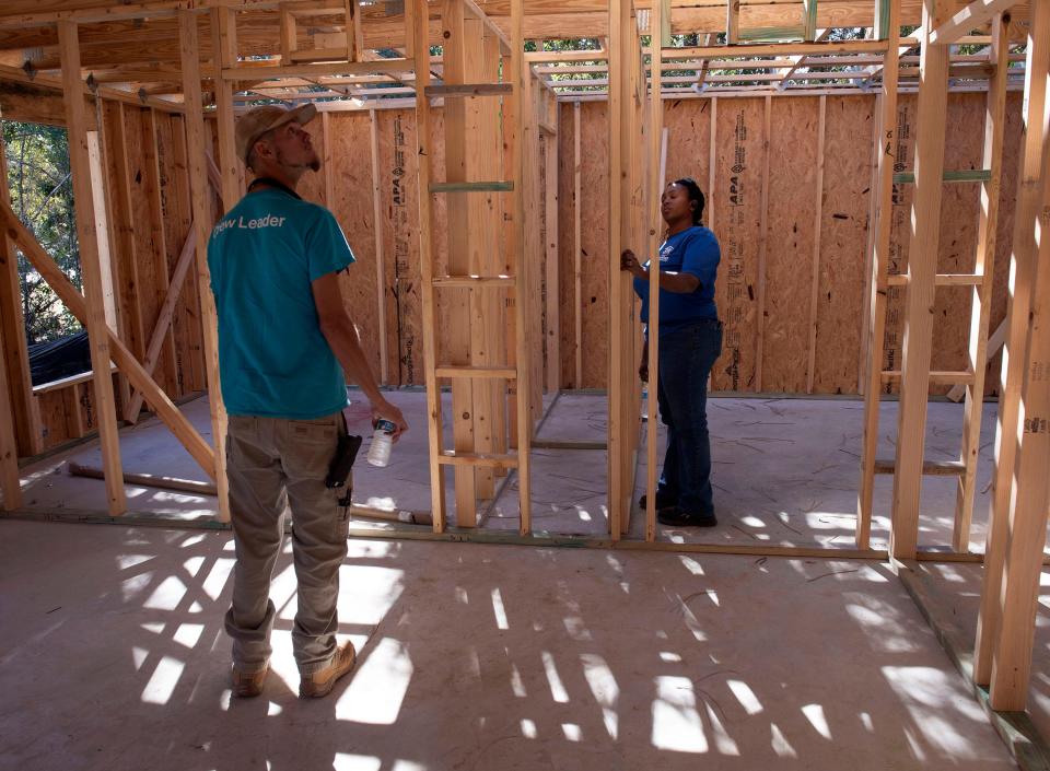 Sam Barker and Marnetia Davis work at a Habitat for Humanity home site on East Milton on Nov. 12.