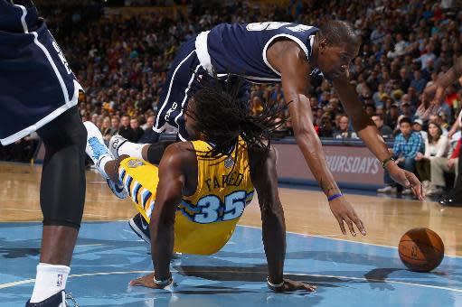 Kevin Durant, de los Oklahoma City Thunder, pierde el balón y cae atropellándose también con Kenneth Faried, #35 de los Denver Nuggets, en duelo de la liga NBA en el estadio Pepsi Center, el 9 de enero de 2014, en Denver. (GETTY IMAGES NORTH AMERICA/AFP | Doug Pensinger)