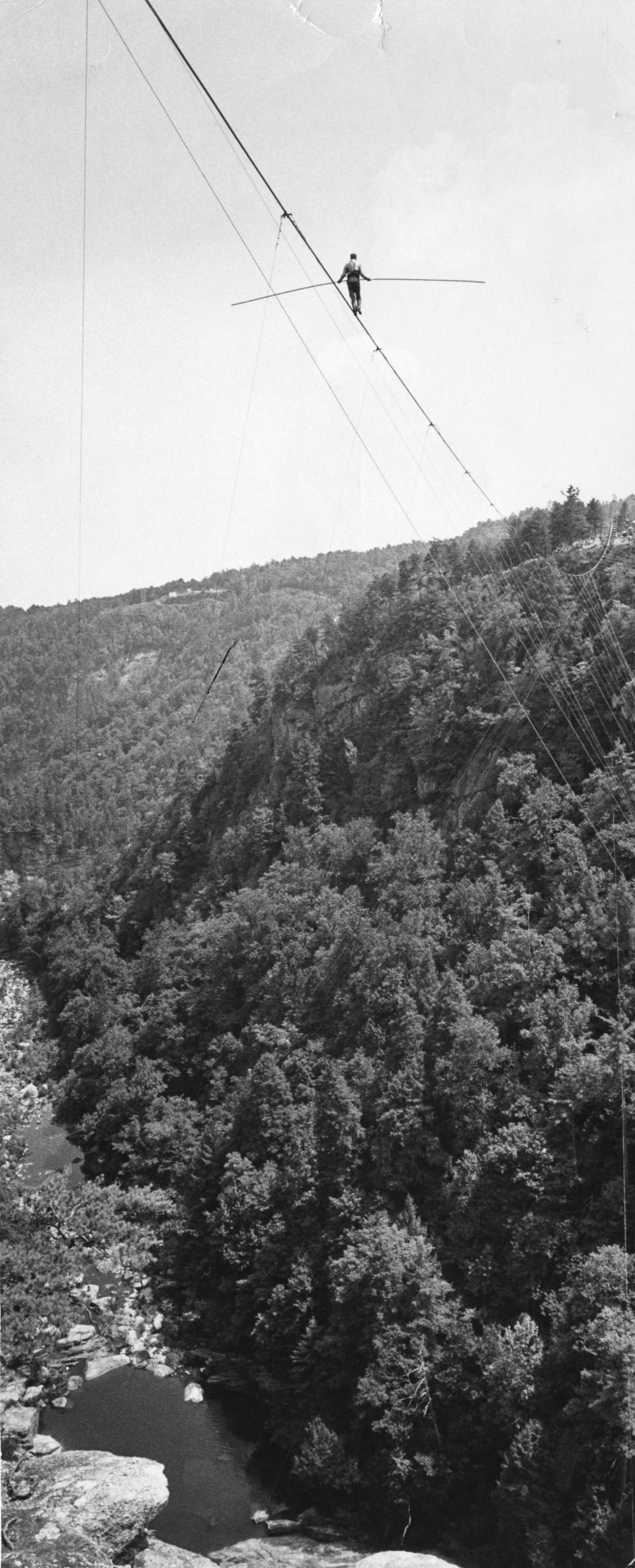 Karl Wallenda, perched hundreds of feet in air, walks on a tightrope over Tallulah Gorge in Georgia on July 18, 1970. Crowds lined cliffs on both sides of the famed chasm to see the aerialist's stunt. (Dwight Ross Jr./Atlanta Journal-Constitution via AP)