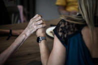 En la fotografía, una de las voluntarias de la aldea agarra de la mano a una de las pacientes. (Foto: Philippe Lopez / AFP / Getty Images).