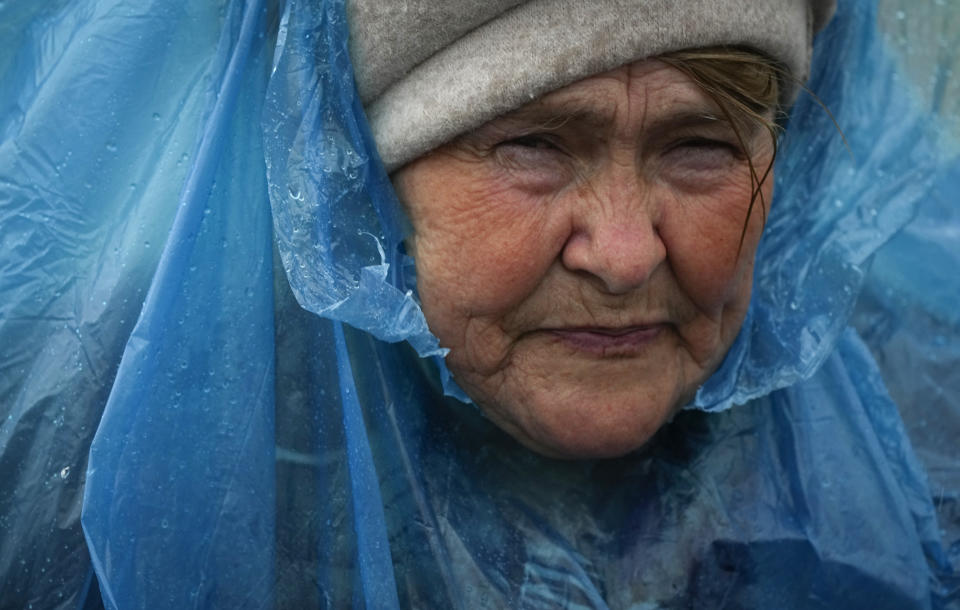 A woman walks during rain after fleeing the war from neighbouring Ukraine at the border crossing in Medyka, southeastern Poland, Saturday, April 9, 2022. (AP Photo/Sergei Grits)