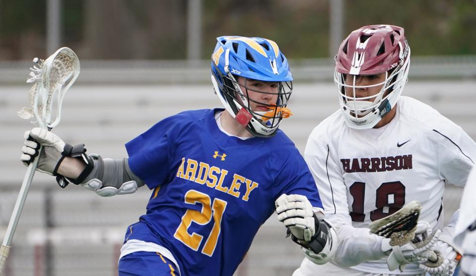 Ardsley's Jake Kaplan (21) works against Harrison's Max Tse (18) during boys lacrosse action at Harrison High School on Saturday, April 13, 2024.