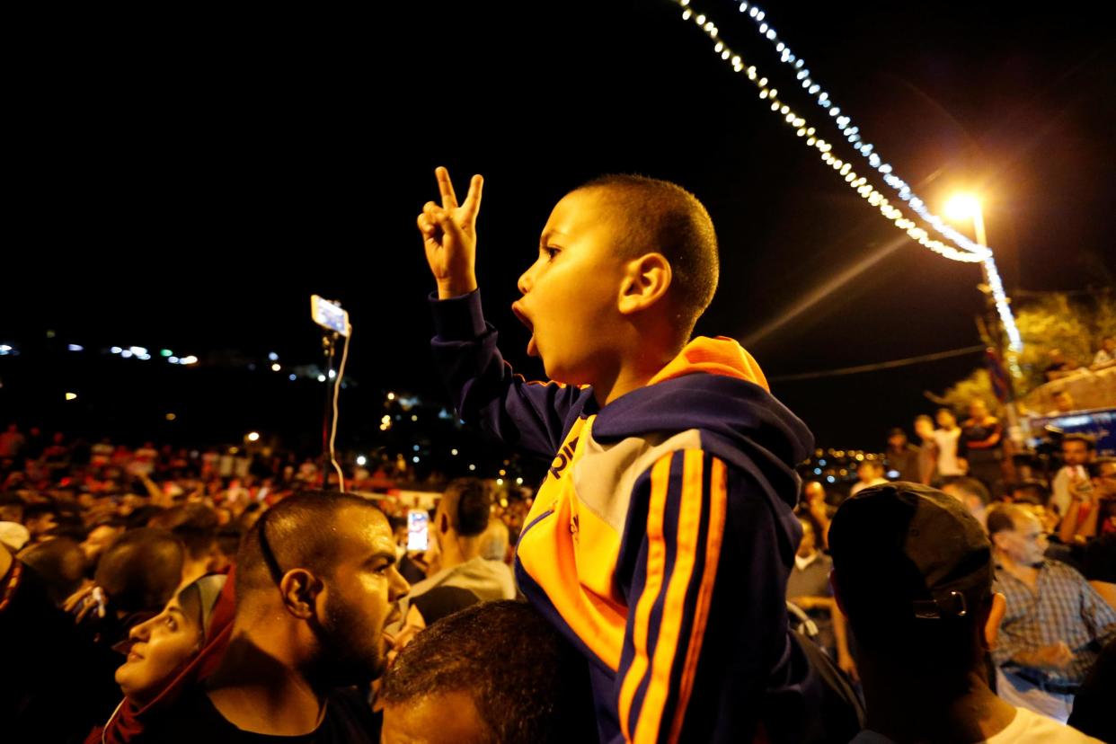 Palestinians celebrate outside the Lion's Gate at the entrance to Jerusalem's Old City following Israel's removal of security measures at a contested holy site in the early hours of 27 July 2017: REUTERS