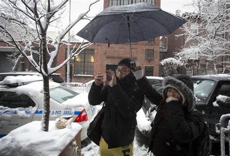 Passersby take photos of a makeshift memorial for actor Philip Seymour Hoffman in front of his apartment building in New York February 3, 2014. REUTERS/Carlo Allegri