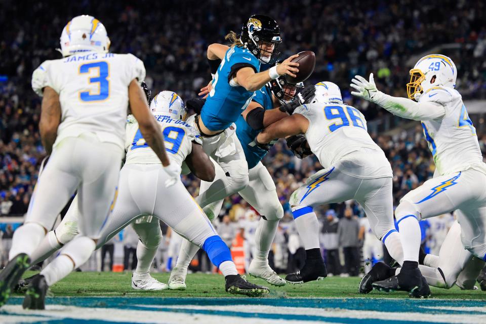 Jaguars quarterback Trevor Lawrence (16) scores a two-point conversion between the Los Angeles Chargers' defensive linemen in the fourth quarter of the Jags' most recent playoff victory in January 2023.