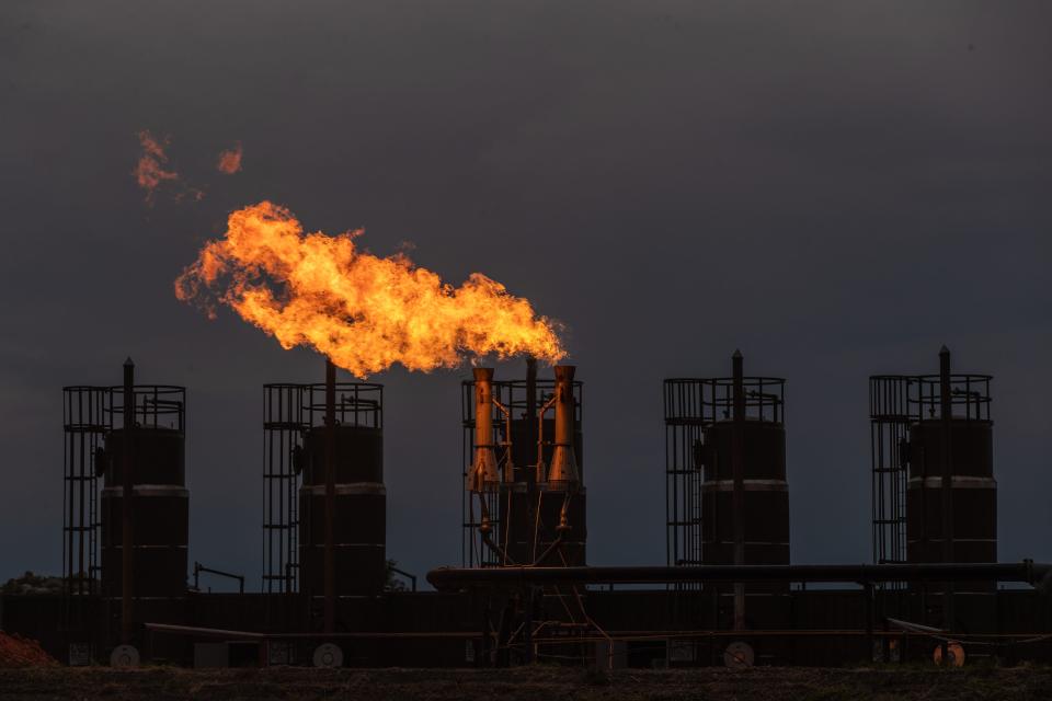 Flames burn on an oil rig at dusk outside New Town, N.D., on the Fort Berthold reservation. Drug dealers are drawn to the area for its few law enforcement officers and willing customer base.