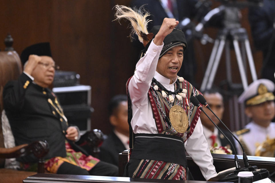 Indonesian President Joko Widodo, wearing traditional attire from Tanimbar Islands of Maluku province, raise his fist as he shouts "Merdeka" (freedom) as he delivers his State of the Nation Address ahead of the country's Independence Day, at the parliament building in Jakarta, Indonesia, Wednesday, Aug. 16, 2023. (Adek Berry/Pool Photo via AP)