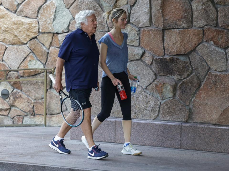 Robert Kraft holding tennis racquet walks with fiancée at Sun Valley conference