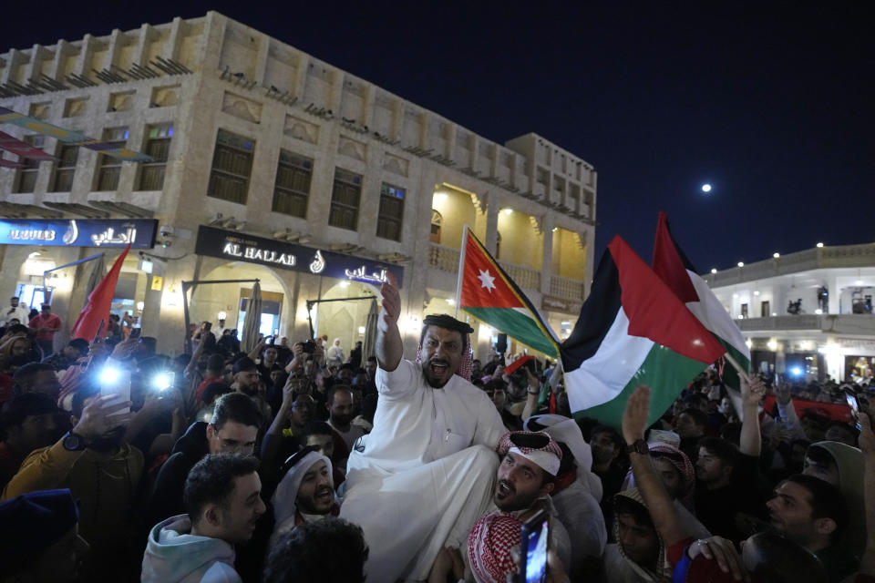 People celebrate in the Souq in Doha, Qatar after Morocco beat Portugal in a World Cup quarterfinal soccer match at Al Thumama Stadium in Doha, Qatar, Saturday, Dec. 10, 2022. (AP Photo/Jorge Saenz)